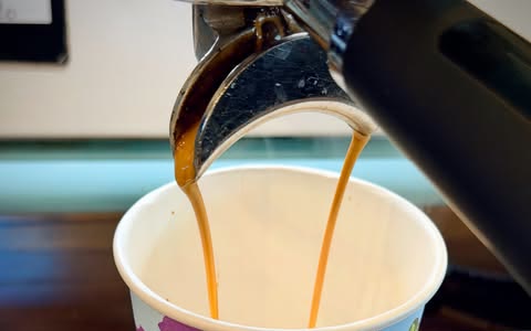 A double shot pouring into a Bean Cartel takeaway cup at Salt n Pepa Cafe.