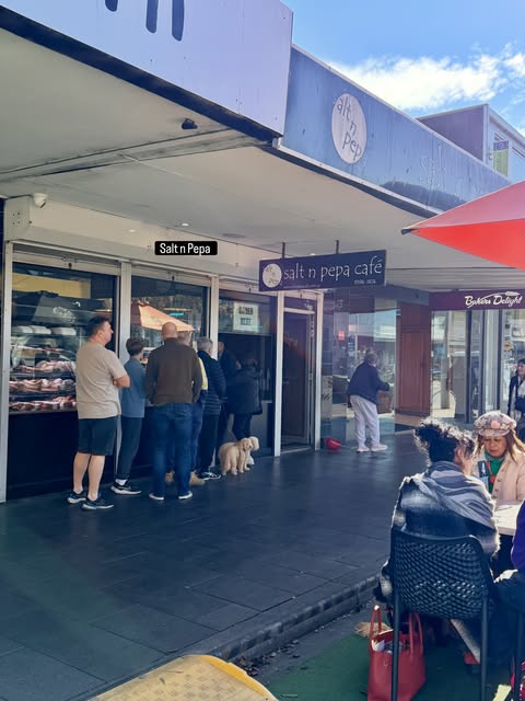 Customers queueing at the pastry cabinet under the blue Salt n Pepa awning on Pier Street, Altona.